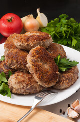 fried meat cutlets decorated with vegetables and herbs