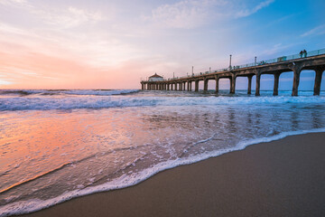 Manhattan beach pier at sunset, orange-pink sky with bright colors, beautiful landscape with ocean and sand