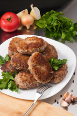 fried meat cutlets decorated with vegetables and herbs