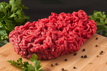 raw minced meat decorated with herbs on a wooden Board