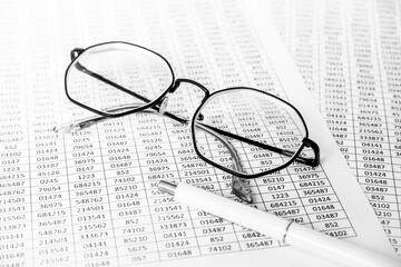 finance business calculation with glasses, tables with numbers and pen. business concept. financial...