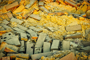 Damaged pavement of gray bricks and yellow sand base, repair street area road works