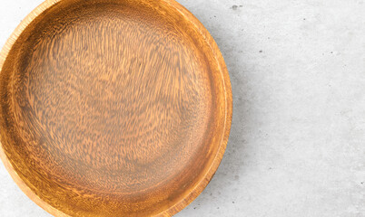 Wooden bowl on cement background