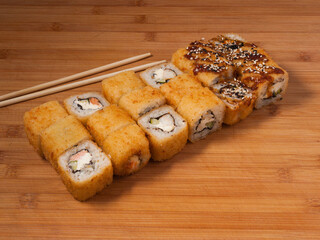 sushi set and sushi roll on wooden board