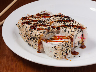 sushi roll with eel, cream cheese and avocado on a white plate