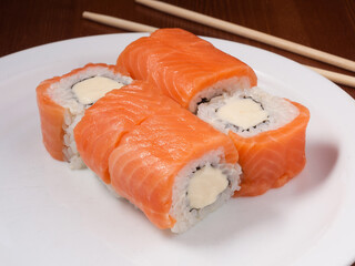 sushi roll with salmon and cream cheese on a white plate