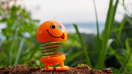 a photo of an orange toy doll with a smiling expression