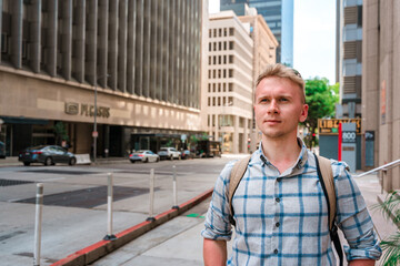 A young blonde man walks the streets in downtown Los Angeles