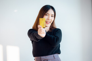 Portrait of charming asian young woman ready to pay with credit card on an online store, isolated over white background