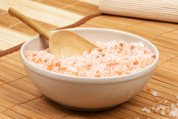 Coarse red Himalayan salt in bowl on bamboo mat