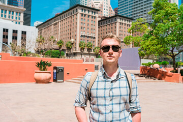 A young blonde man walks the streets in downtown Los Angeles