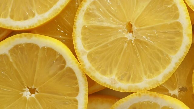 Lemon slices closeup, summer background, fruits top view. Rotation