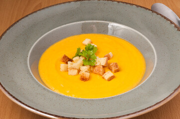 mashed soup with croutons decorated with herbs. close up