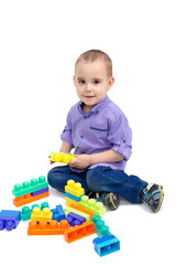 Cheerful child is playing with toys on the floor. Isolate.