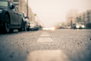 Morning fog in the city, the row of parked cars. Close up view from the level of the dividing line