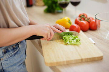 close up of female hands cutting salad