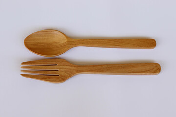 Wooden spoon and fork kitchenware isolated on white background closeup.