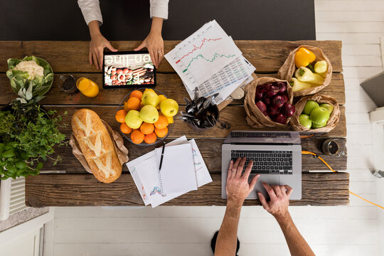 High angle view of people using digital devices in kitchen