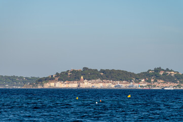 Blue water of Gulf of Saint-Tropez with outlines of Saint-Tropez town on background, French...