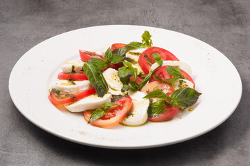 Caprese salad with tomatoes and mozzarella on a white plate