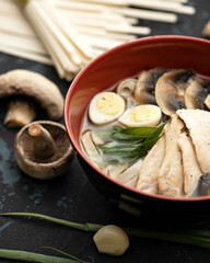 Exotic soup with meat, Champignon mushrooms and eggs. Bowl of hot and Spicy oriental dish. Pan-Asian cuisine. Soft focus. Vertical format.