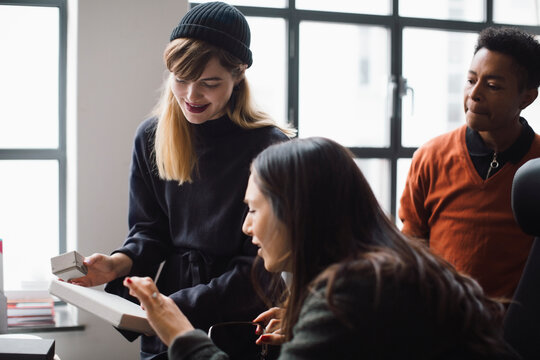 Female and male coworkers discussing over product in office