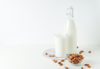 A glass with almond milk and the bowl with almonds