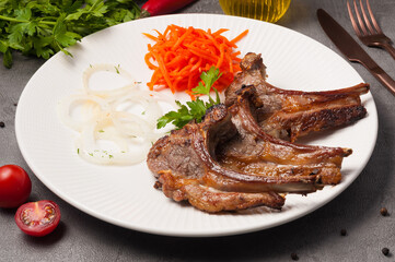 lamb loin with onions and carrots on a white plate