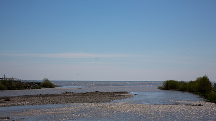 The river flows into the sea. Meeting of freshwater and salt water. The concept - everything tends to become big