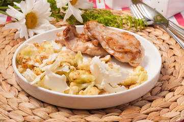 grilled pork with cauliflower fries on a white plate