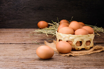 Fresh organic farm eggs are placed on the table and placed in a basket on the kitchen wooden table.