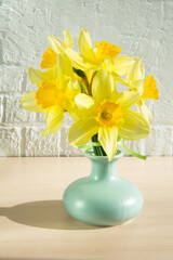 yellow daffodil flowers in a vase upright
