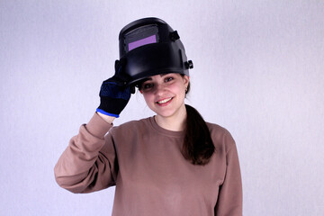 Girl in a welding mask and work gloves