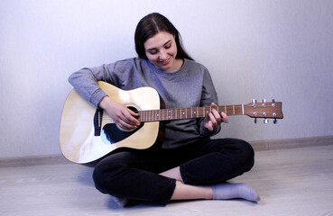 Smiling girl playing acoustic guitar