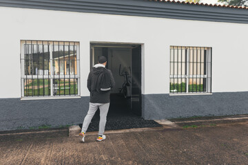 Man arriving at the gym. Backpack and cap.