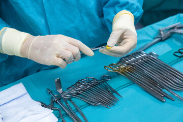 Medical team performing operation. Close up of scrub nurse taking medical instruments for...