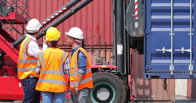 Hispanic man harbor worker talking on the walkie-talkie radio and control loading containers at container warehouse. container yard port of import and export goods