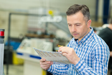 man checking printed matter through magnifying device