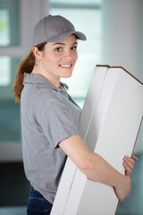 a woman is carrying boxes