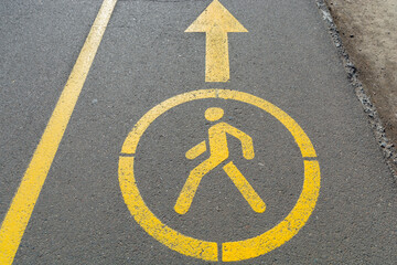 Yellow sign denoting pedestrian space on the road. Walking road in the park. Pedestrian figurine...