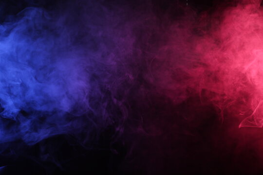 Artificial smoke in red-blue light on black background darkness