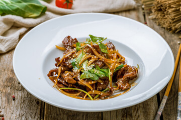 Fried lamb with vegetables Chinese cuisine on old wooden table
