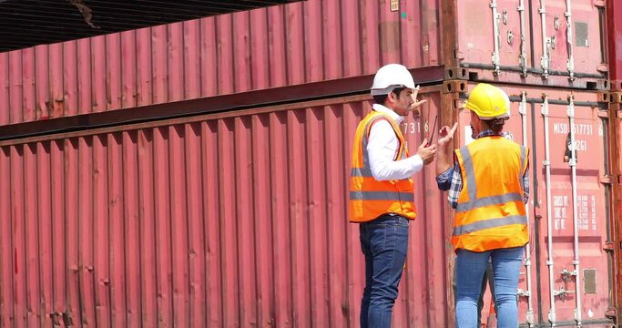 Hispanic man harbor worker talking on the walkie-talkie radio and control loading containers at container warehouse. container yard port of import and export goods