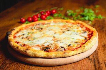 Italian pizza with cheese tomatoes, arugula and mushrooms on wooden cutting board stock photo.