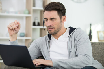 Fototapeta premium young man with laptop on sofa in the room