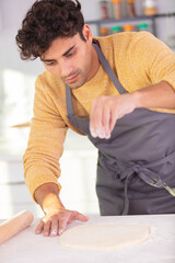 male baker sprinkling flour on pastry