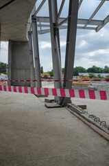 Construction site with metal columns fenced with a signal tape