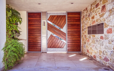 Athens Greece, modern house entrance stone wall with wood, glass and stainless steel door