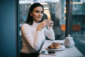 Glad female with cup of hot coffee