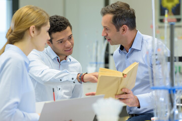 Fototapeta premium male student using pointing at book in science class